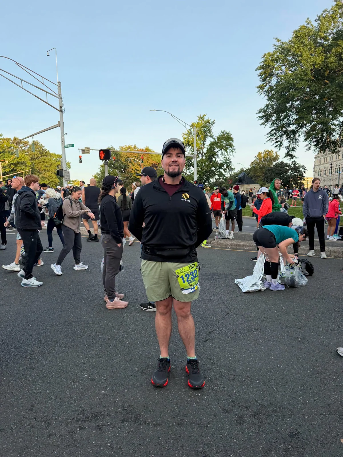 Savy sales representative Matt wearing a company athletic top and race bib among marathon participants on a city street