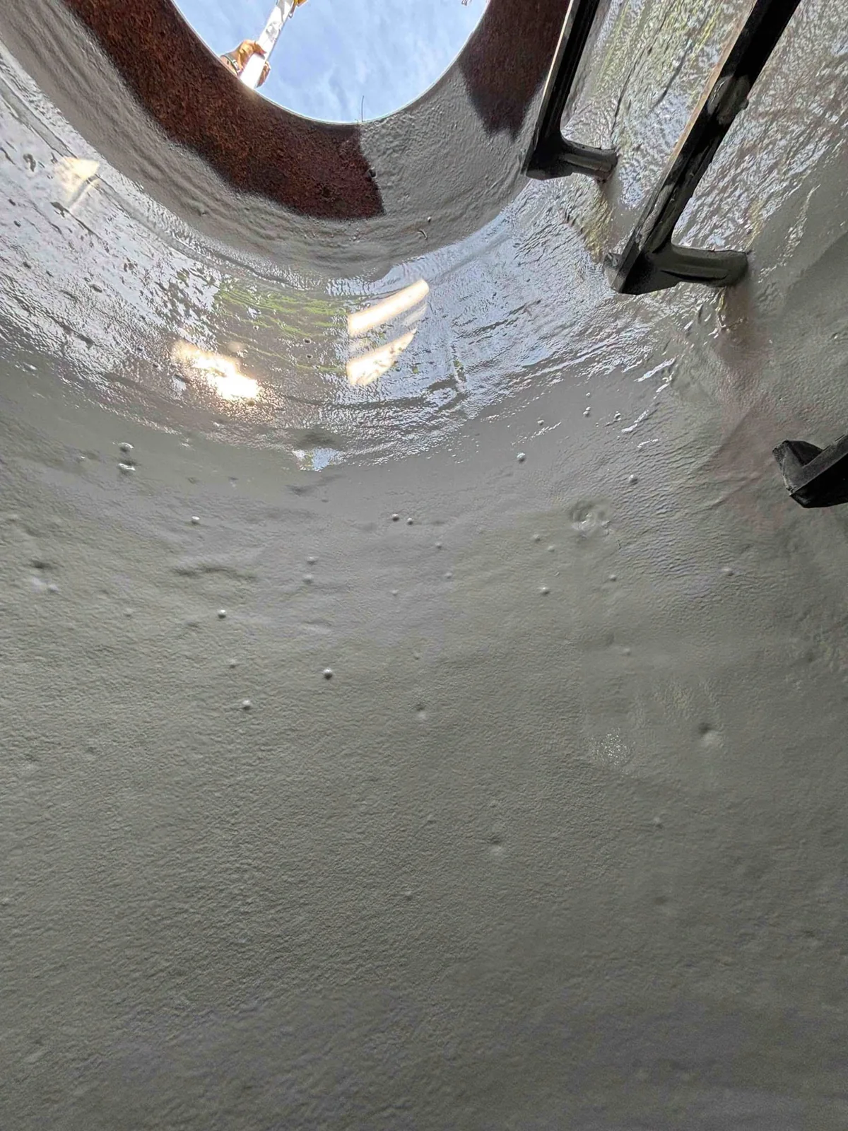 Protective coating inside a manhole, looking up toward the access opening