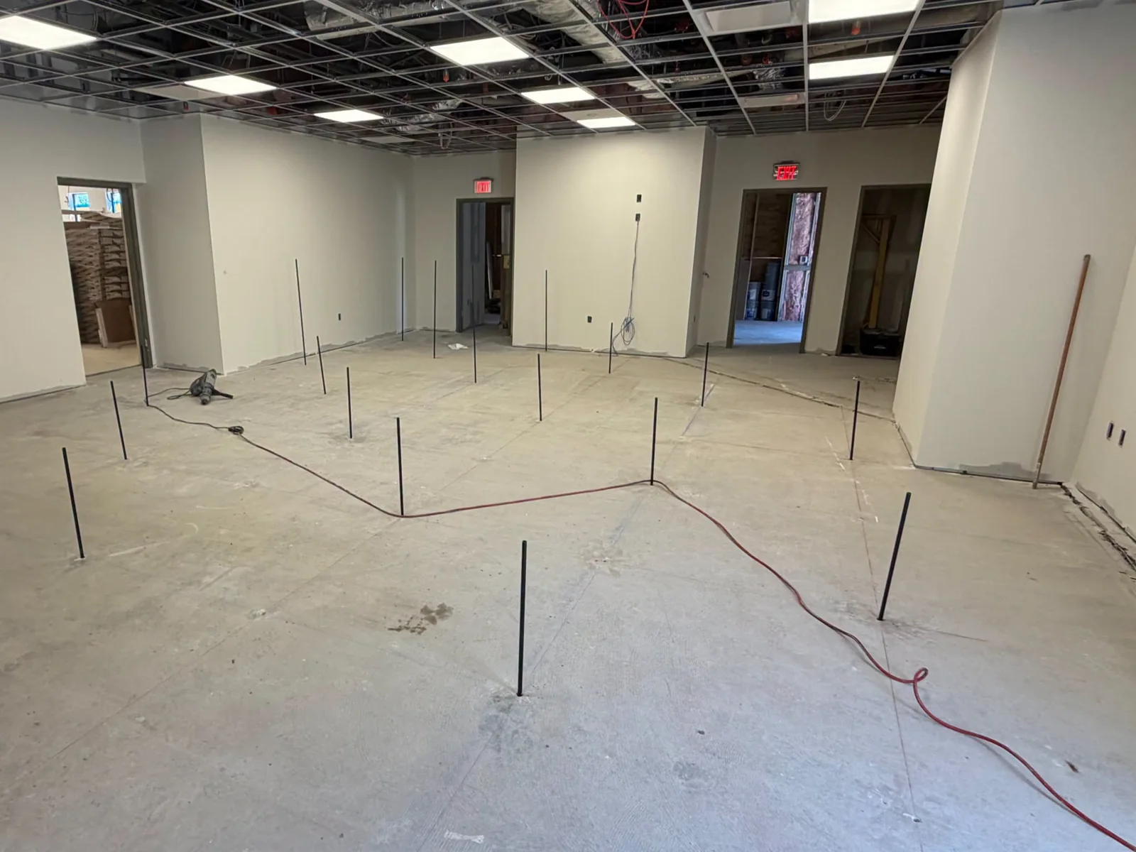 Injection stems and hoses arranged across a concrete slab indoors