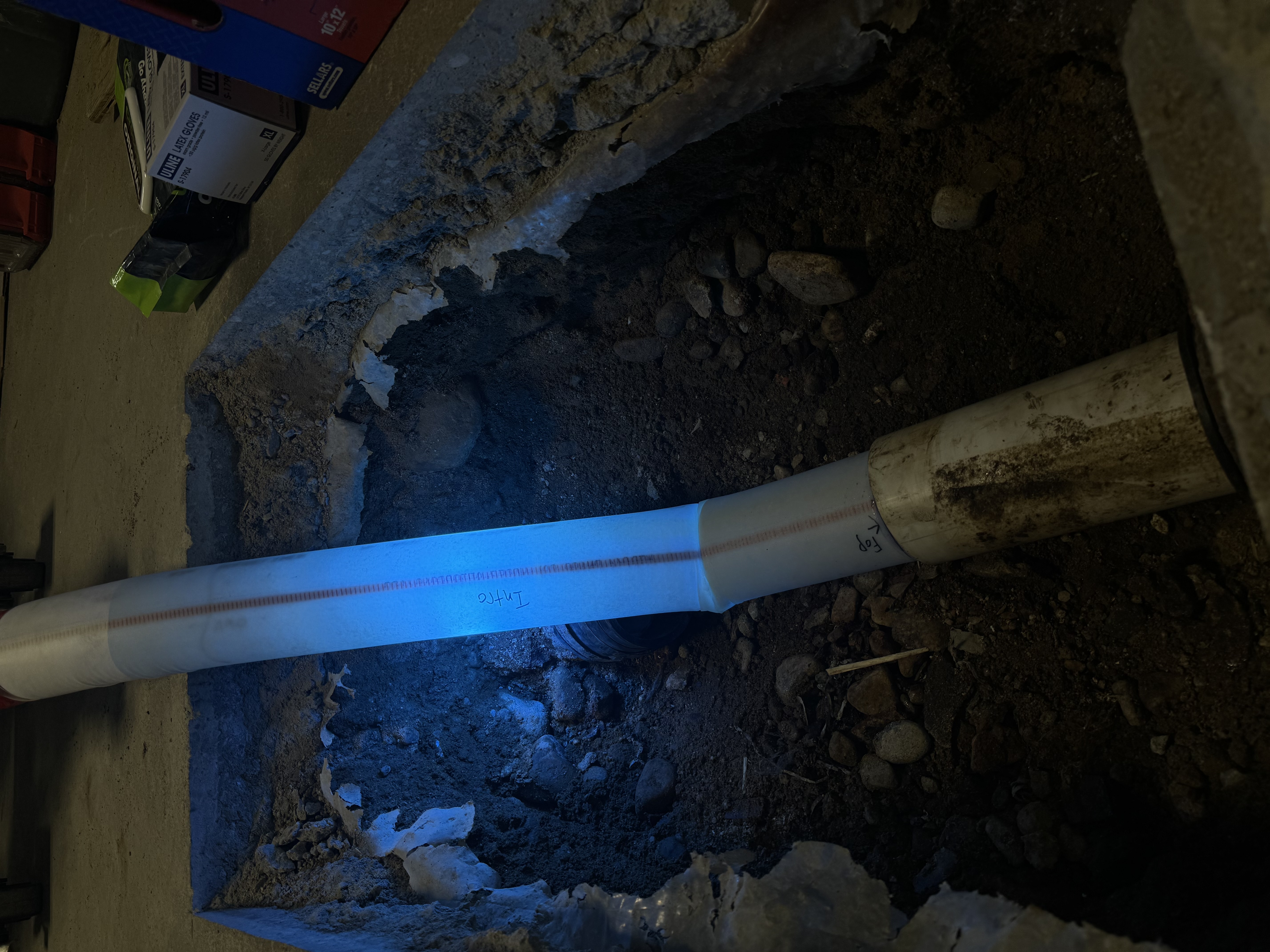 CIPP liner curing in an access pit opened inside an occupied commercial space